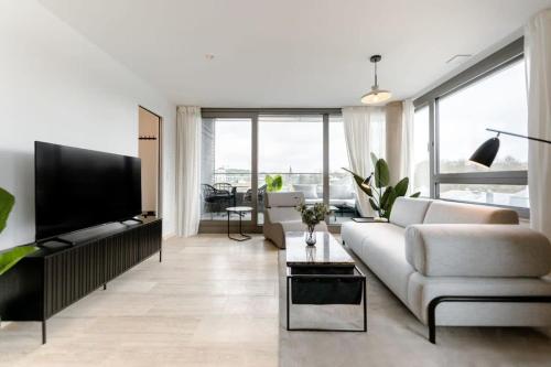a living room with a white couch and a flat screen tv at City Luxury with City Views in Ville Haute in Luxembourg