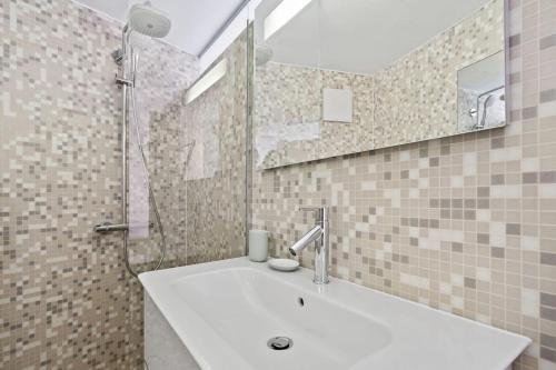La salle de bains est pourvue d'un lavabo et d'un miroir. dans l'établissement Modern Apt in Old Town w Panoramic View ID4, à Luxembourg