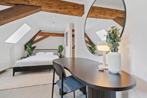 a bedroom with a table and a bed and a mirror at Escape to Clausen Stylish Apartment ID212 in Luxembourg