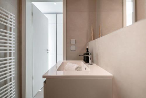 a white bathroom with a sink and a mirror at Prime Location Modern Gem in Gasperich in Luxembourg