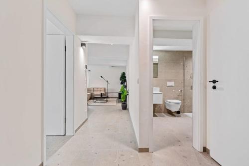 un couloir ouvert avec des murs blancs et une chambre avec des toilettes dans l'établissement Clausen Charm Contemporary Retreat ID210, à Luxembourg