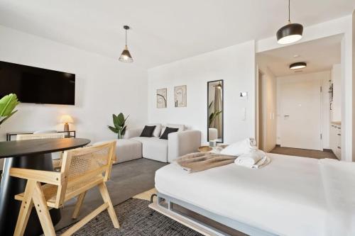 ein weißes Wohnzimmer mit einem Bett und einem Schreibtisch in der Unterkunft Premium City Stay in Cessange ID204 in Luxemburg (Stadt)