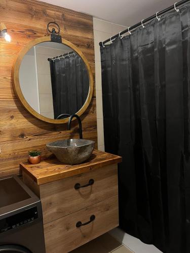 une salle de bain avec un lavabo et un miroir dans l'établissement Chalet Martin Belle-Vue, à Aime La Plagne