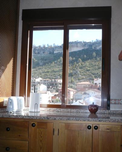 a window in a kitchen with a view of a city at APARTAMENTOS Y HABITACIONES RURALES "El Corral" in Cañizares