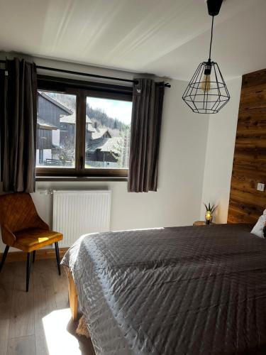 une chambre avec un lit et une grande fenêtre dans l'établissement Chalet Martin Belle-Vue, à Aime La Plagne