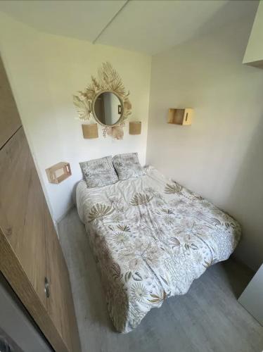 une chambre avec un lit et un miroir au mur dans l'établissement EXCEPTIONNEL - Appartement dans village vacances CAP ESTEREL AGAY - ST RAPHAEL, à Saint-Raphaël