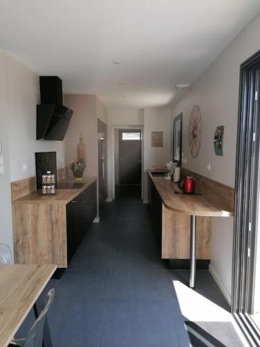 une grande cuisine avec des comptoirs en bois et un couloir dans l'établissement Maison familiale 120 m2 à 15 minutes de la mer, à Lanmeur