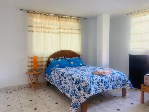 een slaapkamer met een bed met een blauw dekbed bij Emilia house in Urubamba