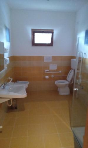 ein Bad mit einem WC, einem Waschbecken und einem Fenster in der Unterkunft Affittacamere al picchio verde in Monsampietro Morico