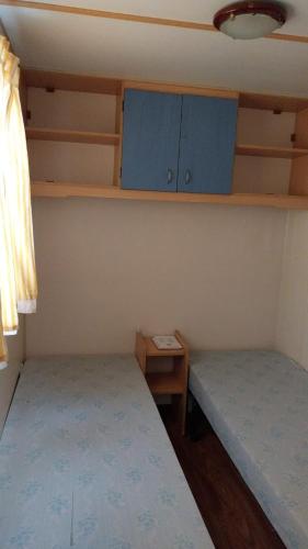 a small room with two beds and a table at Lands House Bungalows in Pataias