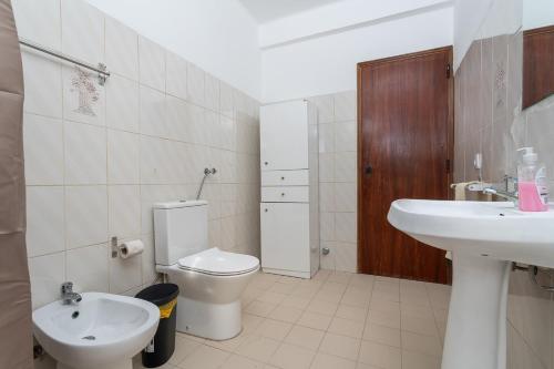 a white bathroom with a toilet and a sink at BLife Marya private rooms - Airport stay in Faro
