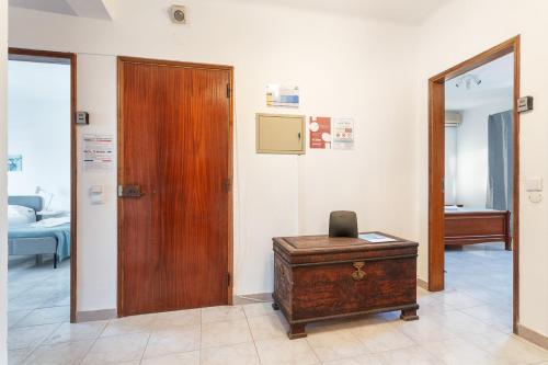 a room with a wooden door and a desk at BLife Marya private rooms - Airport stay in Faro