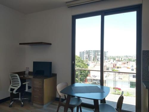 un bureau avec un bureau, une table et une fenêtre dans l'établissement Suite Loft Amplio Nuevo Salida a CDMX 204A, à Querétaro