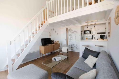 un salon avec un canapé et un escalier dans l'établissement Le Landifornia - Design cosy & horizon bleu avec vue océan, à Seignosse