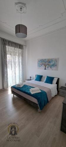 - une chambre avec un grand lit et une couverture bleue dans l'établissement La Terra di Cerere, à Trapani