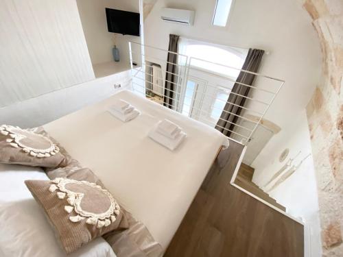a bedroom with a white bed and a mirror at Stella Marina Luxury in Polignano a Mare