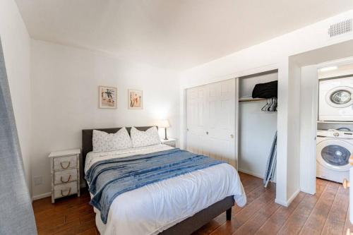 um quarto com uma cama e uma máquina de lavar roupa em Cactus Rd 2 BR Condo with Pool View Balcony em Phoenix