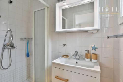 ein weißes Badezimmer mit Waschbecken und Dusche in der Unterkunft La Vinière - Villa avec piscine in Saint-Hilaire-de-Talmont