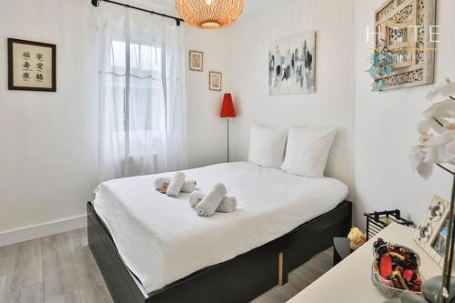 ein Schlafzimmer mit einem Bett mit weißen Laken und einem Fenster in der Unterkunft La Vinière - Villa avec piscine in Saint-Hilaire-de-Talmont