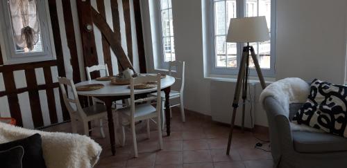 une salle à manger avec une table, des chaises et une lampe dans l'établissement Le Petit Honfleur, à Honfleur