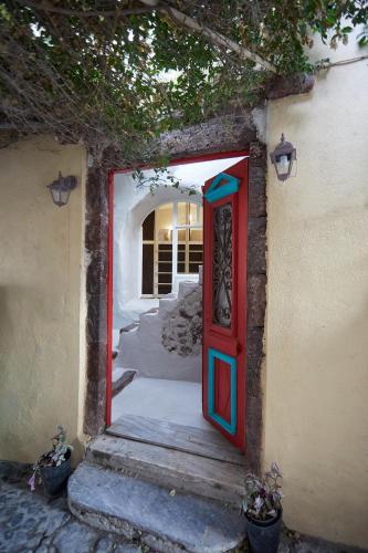 a red and blue door leading into a house at Hostel 16 Oia in Oia