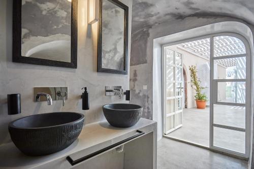 a bathroom with a sink and a large mirror at Hostel 16 Oia in Oia