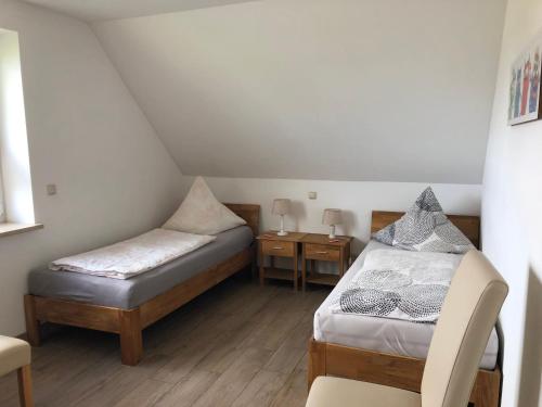 ein kleines Zimmer mit 2 Betten und einem Stuhl in der Unterkunft Haus Hanni in Priepert