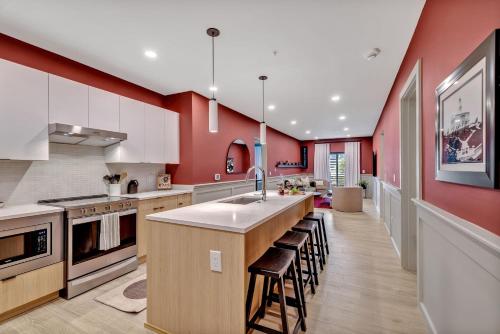 納許維爾的住宿－Nashville - 635 7th Ave S Unit 412，一间带红色墙壁的厨房和一个带凳子的厨房岛