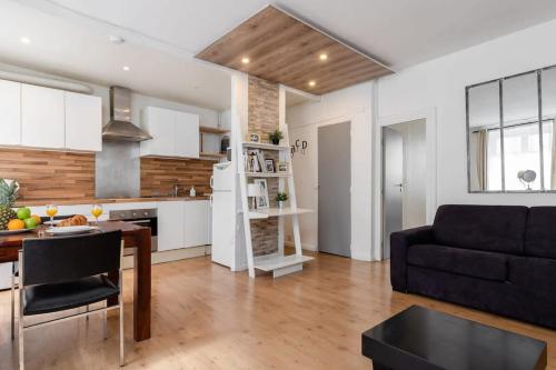 a kitchen and living room with a couch and a table at Champ de Mars & Rue de Grenelle - CityApartmentStay in Paris