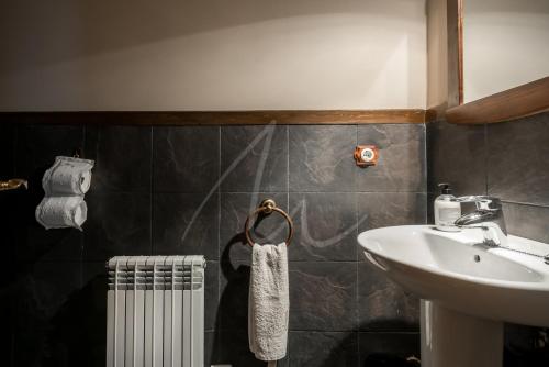 a bathroom with a sink and a white towel at Casa Garona by SeaMount Rentals in Bossòst