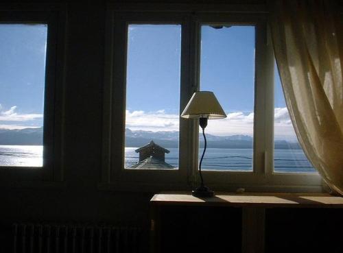 a lamp sitting in front of a window with a view of the ocean at Bariloche Hostel in San Carlos de Bariloche