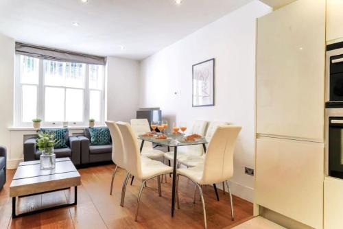 uma cozinha e sala de estar com mesa e cadeiras em Notting Hill & Hyde Park - CityApartmentStay em Londres