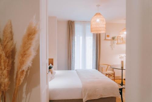 a bedroom with a bed and a table and a window at Apparts' Rennes BnB Duhamel- Centre Gare in Rennes