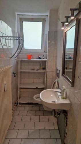 uma casa de banho com um lavatório e uma janela em Rathenaustraße em Berlim