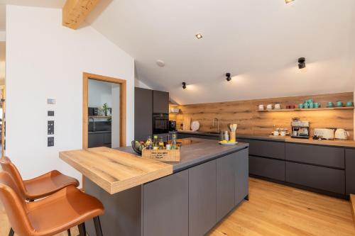 a kitchen with a large island with a wooden counter top at Chiemgauloft , 5 Sterne Ferienwohnung am Chiemsee in Übersee