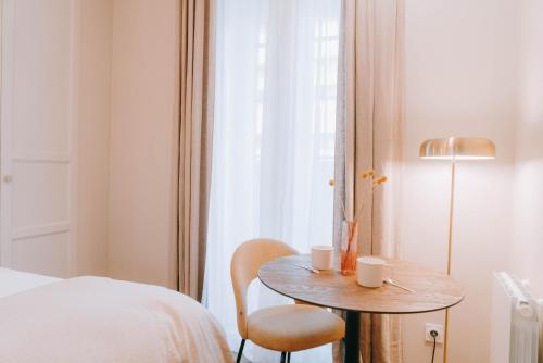 a bedroom with a table and a bed and a window at Apparts' Rennes BnB Duhamel- Centre Gare in Rennes