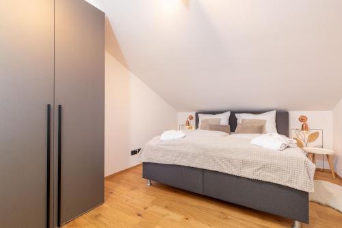 a bedroom with a large bed and a closet at Chiemgauloft , 5 Sterne Ferienwohnung am Chiemsee in Übersee