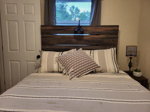 a bed with a wooden headboard and two pillows at City Scape Homey 1 BR efficiency Apt near TTU and downtown in Cookeville