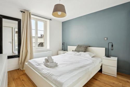 een slaapkamer met een wit bed en een raam bij Les Halles & Le Marais - CityApartmentStay in Parijs