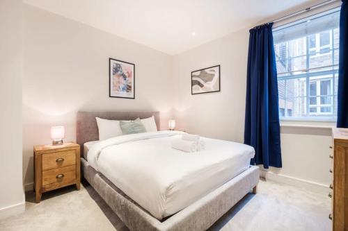 City of London - CityApartmentStay في لندن: غرفة نوم بسرير ابيض كبير ونافذة