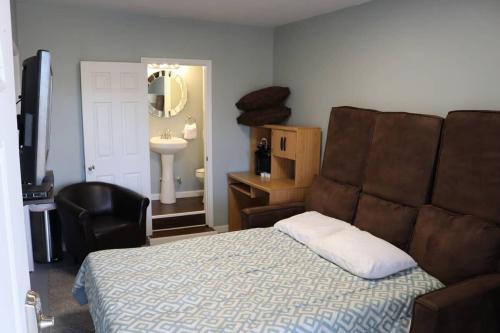 een slaapkamer met een bed, een stoel en een wastafel bij Guest Area for Rent, Your own space! in Hendersonville
