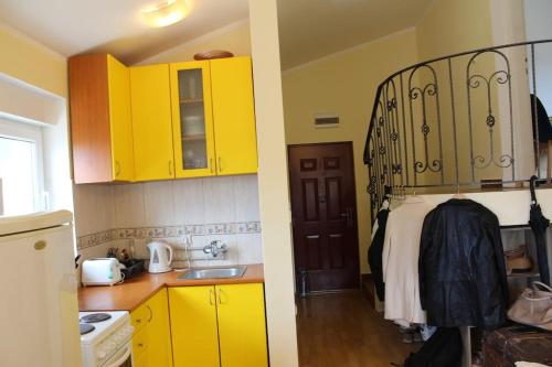 eine Küche mit gelben Schränken und ein Bett in einem Zimmer in der Unterkunft 2-level apartment with terraces by the sea in Budva