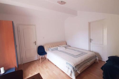ein Schlafzimmer mit einem Bett und einem blauen Stuhl in der Unterkunft 2-level apartment with terraces by the sea in Budva