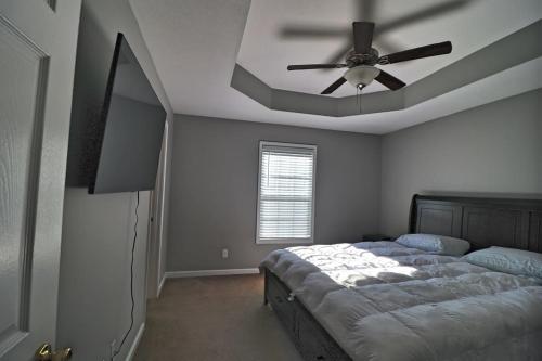 1 dormitorio con ventilador de techo y 1 cama en Beautiful cul-de-sac home!!! with a FENCED IN YARD!, en Clarksville