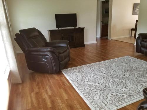 a living room with a chair and a television at Spacious 3BR 2BA, 11 Min to Cummins Falls Park in Cookeville