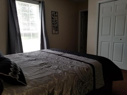 a bedroom with a bed and a window and a door at Spacious 3BR 2BA, 11 Min to Cummins Falls Park in Cookeville