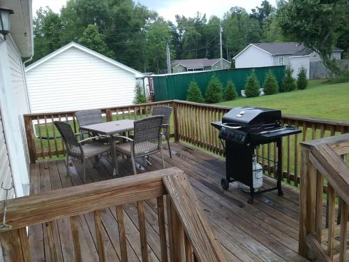 a grill on a deck with a table and chairs at Spacious 3BR 2BA, 11 Min to Cummins Falls Park in Cookeville