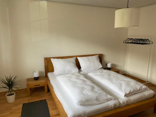 1 dormitorio con 1 cama con sábanas y almohadas blancas en Bayerwaldnest, en Spiegelau