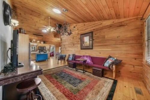 a living room with wooden walls and a purple couch at Pigeon Ridge Cabin Cumberland State Park 2B 2B in Crossville