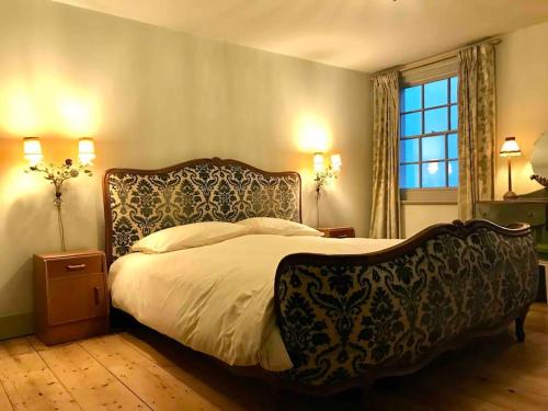 een slaapkamer met een groot bed met een groot hoofdeinde bij Beautiful Beachfront Townhouse in St. Leonards
